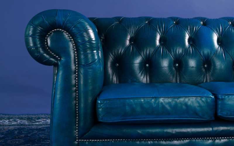 Button tufting detail on a leather Chesterfield sofa