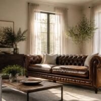 Leather Chesterfield sofa in a sunny living room with sheer curtains filtering the light